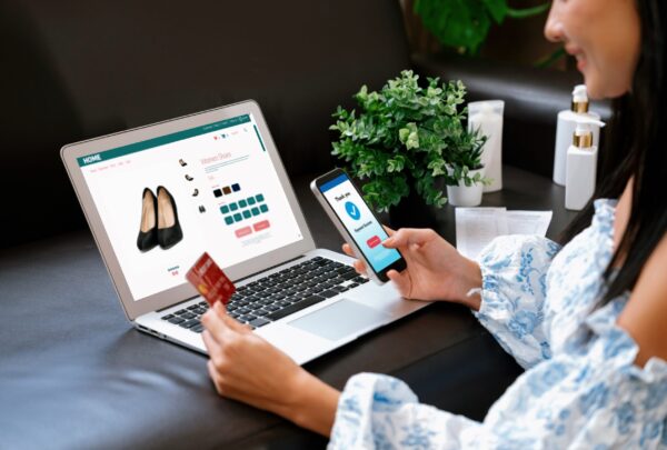 Young woman order or purchase product on internet using laptop and make transaction payment by smartphone. Online shopping lifestyle with credit card via internet banking on mobile application. Blithe