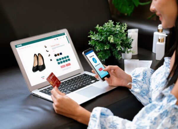 Young woman order or purchase product on internet using laptop and make transaction payment by smartphone. Online shopping lifestyle with credit card via internet banking on mobile application. Blithe