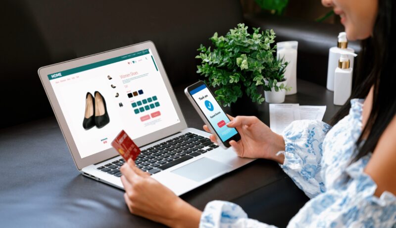 Young woman order or purchase product on internet using laptop and make transaction payment by smartphone. Online shopping lifestyle with credit card via internet banking on mobile application. Blithe